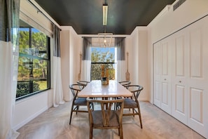 Striking dining space with bold design, natural light, and sleek modern furnishings. Dark ceilings and warm wood accents create a sophisticated atmosphere for memorable meals. - Play Golf & Pickleball! Luxury Lakewood Townhome (Bradenton)