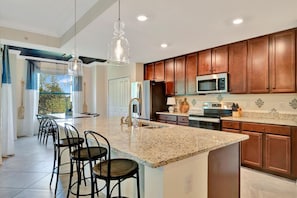 Step into your spacious gourmet kitchen with warm cherry cabinets, granite countertops, and modern appliances. Perfect for family meals or entertaining guests at the breakfast bar. - Play Golf & Pickleball! Luxury Lakewood Townhome (Bradenton)