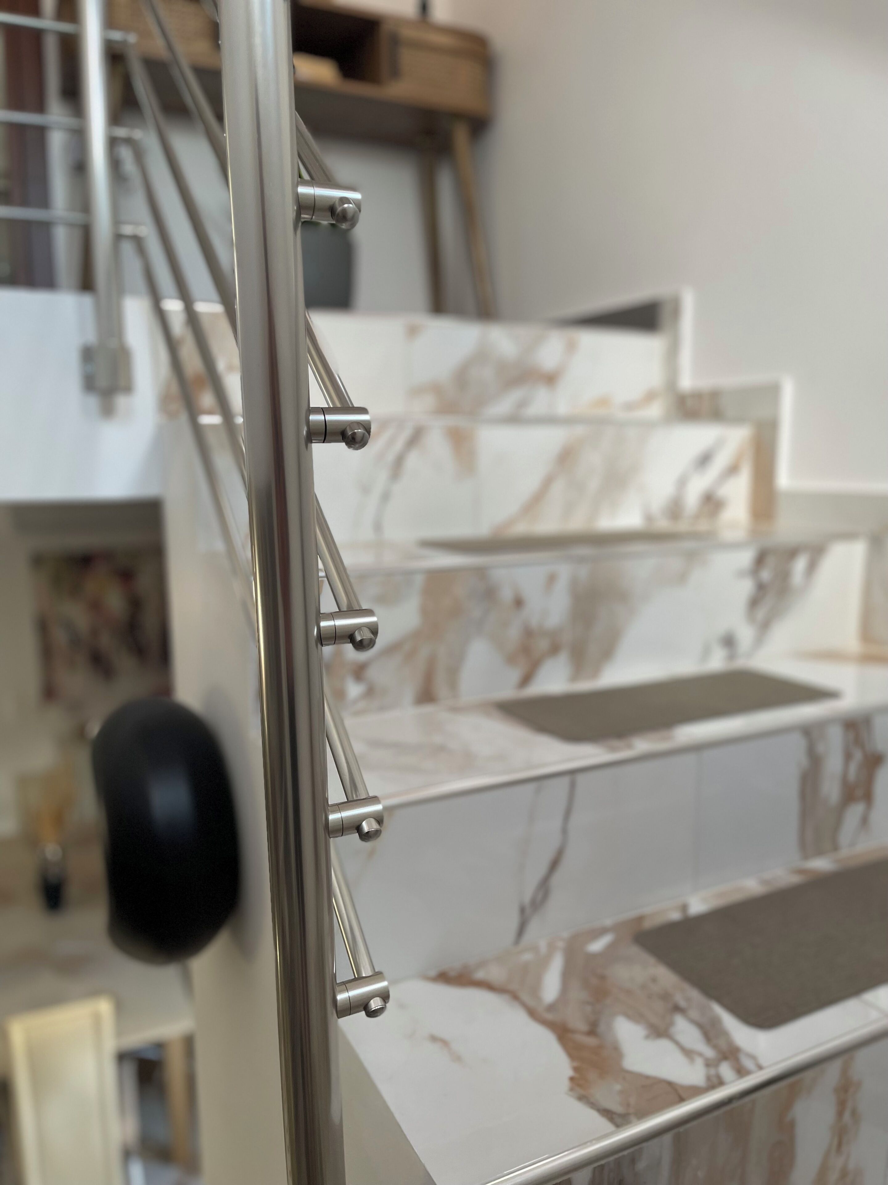 A staircase with a metal railing and marble steps.