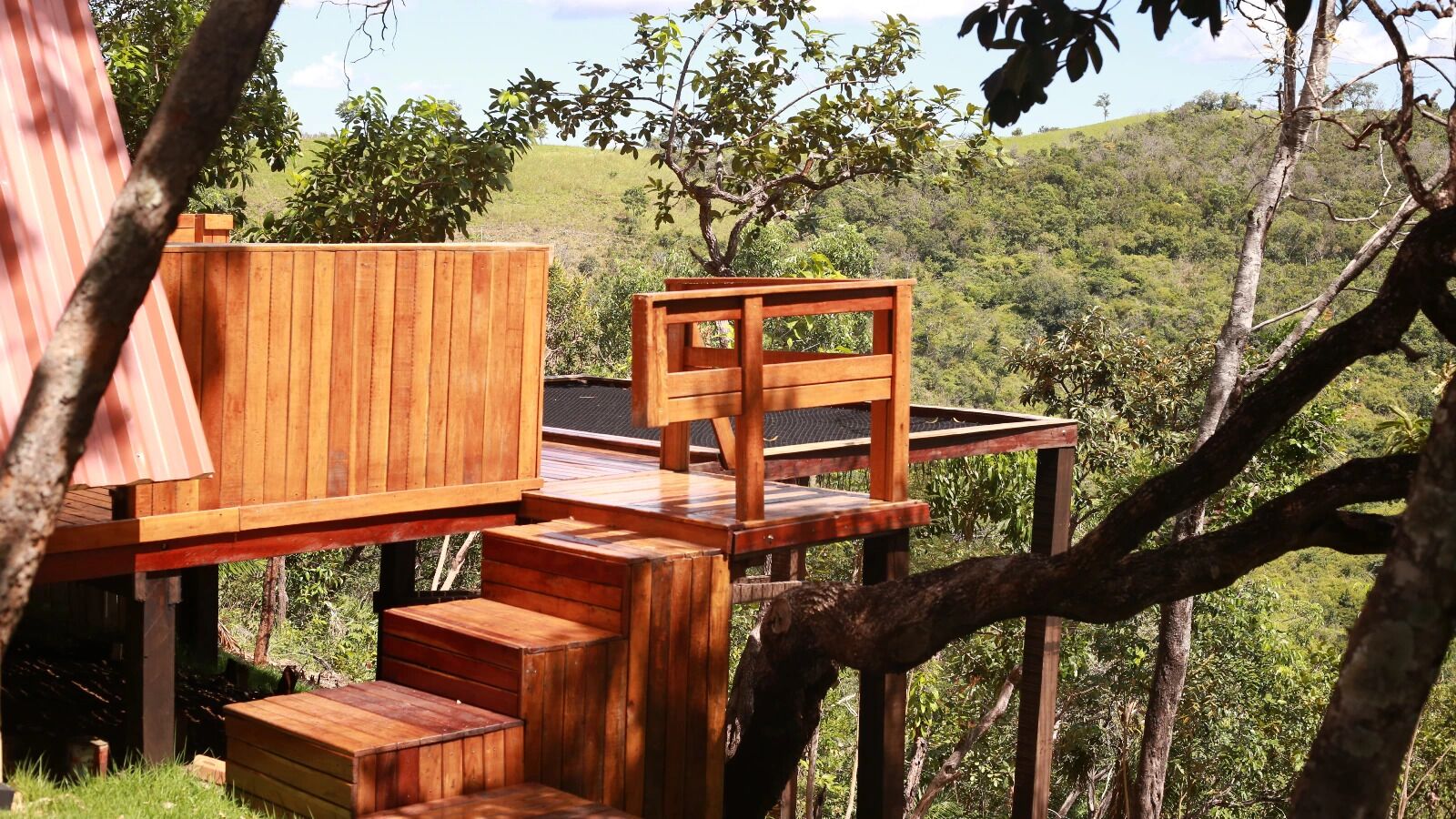 A wooden deck with built-in seating and steps leading to a raised platform.