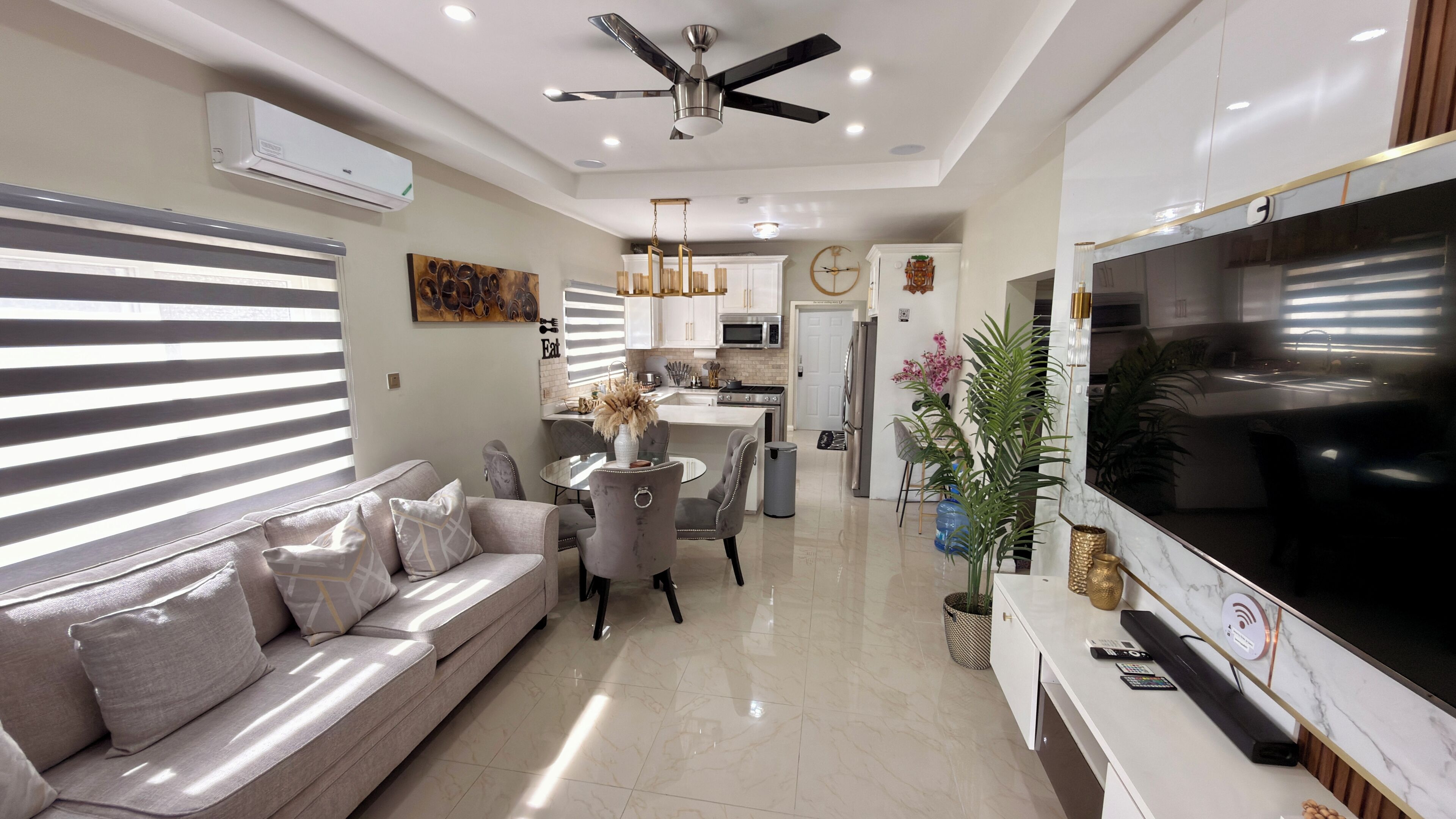 A modern living room with a sofa, dining table, and TV.