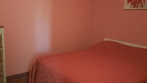 Una habitación con cama, cómoda y un cartel en la pared.