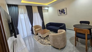 Una sala moderna con sofá, sillones, una mesita de centro y una mesa de comedor.