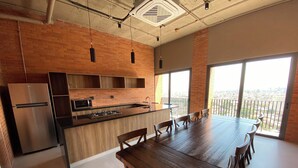 Una cocina moderna con una mesa grande y sillas, un refrigerador y una estufa.