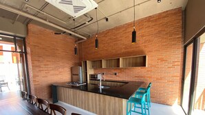 Una cocina moderna con pared de ladrillo, armarios de madera y una isla central con taburetes de bar.