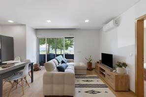 Un soggiorno moderno con divano, TV e zona pranzo.