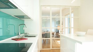 A modern kitchen with a glass backsplash, a black stovetop, and a red decorative item on the counter. - Hidden Gem-Villa with private pool Bellagio view (Lierna)