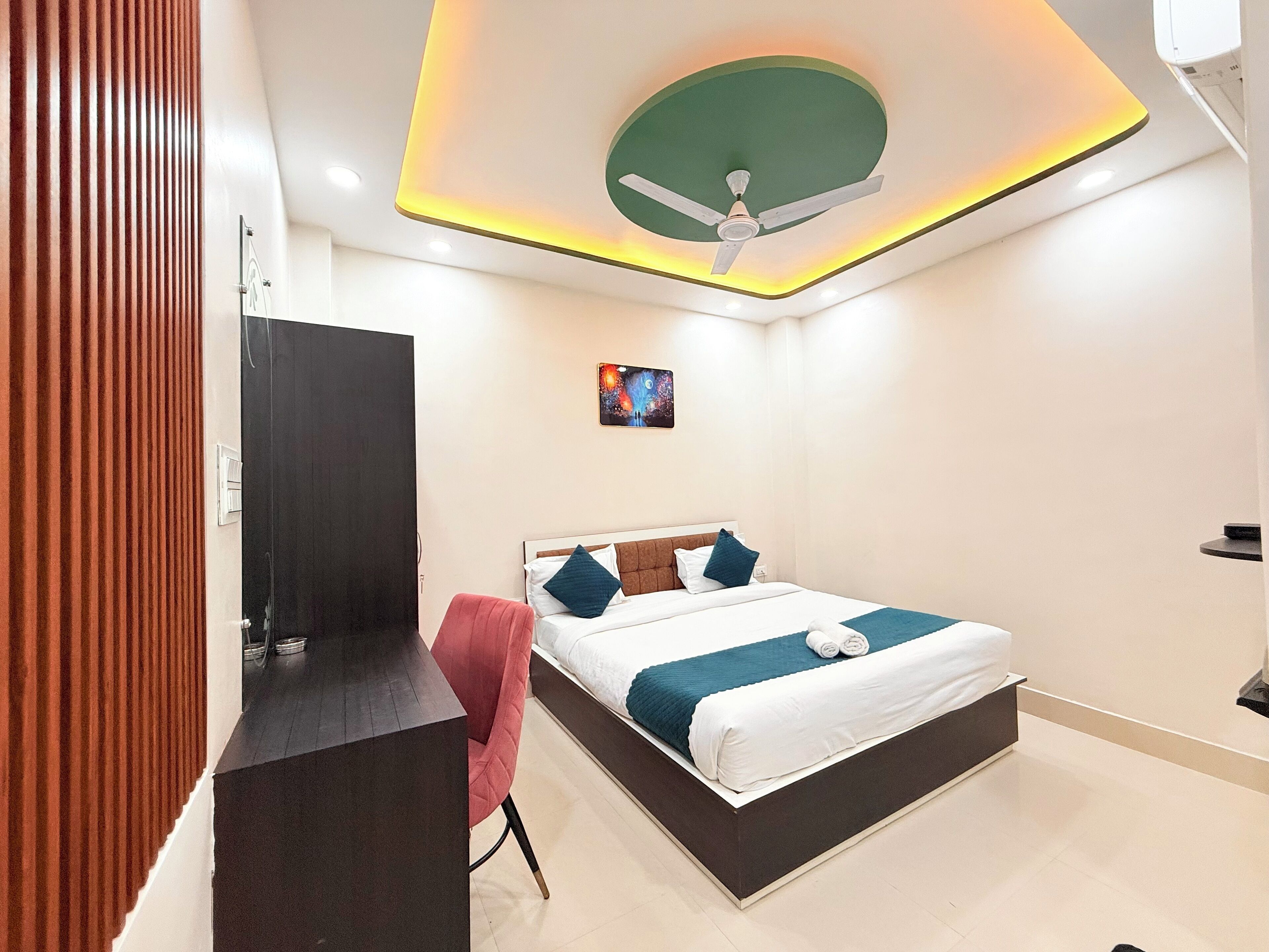 A modern hotel room with a bed, a desk, and a chair.