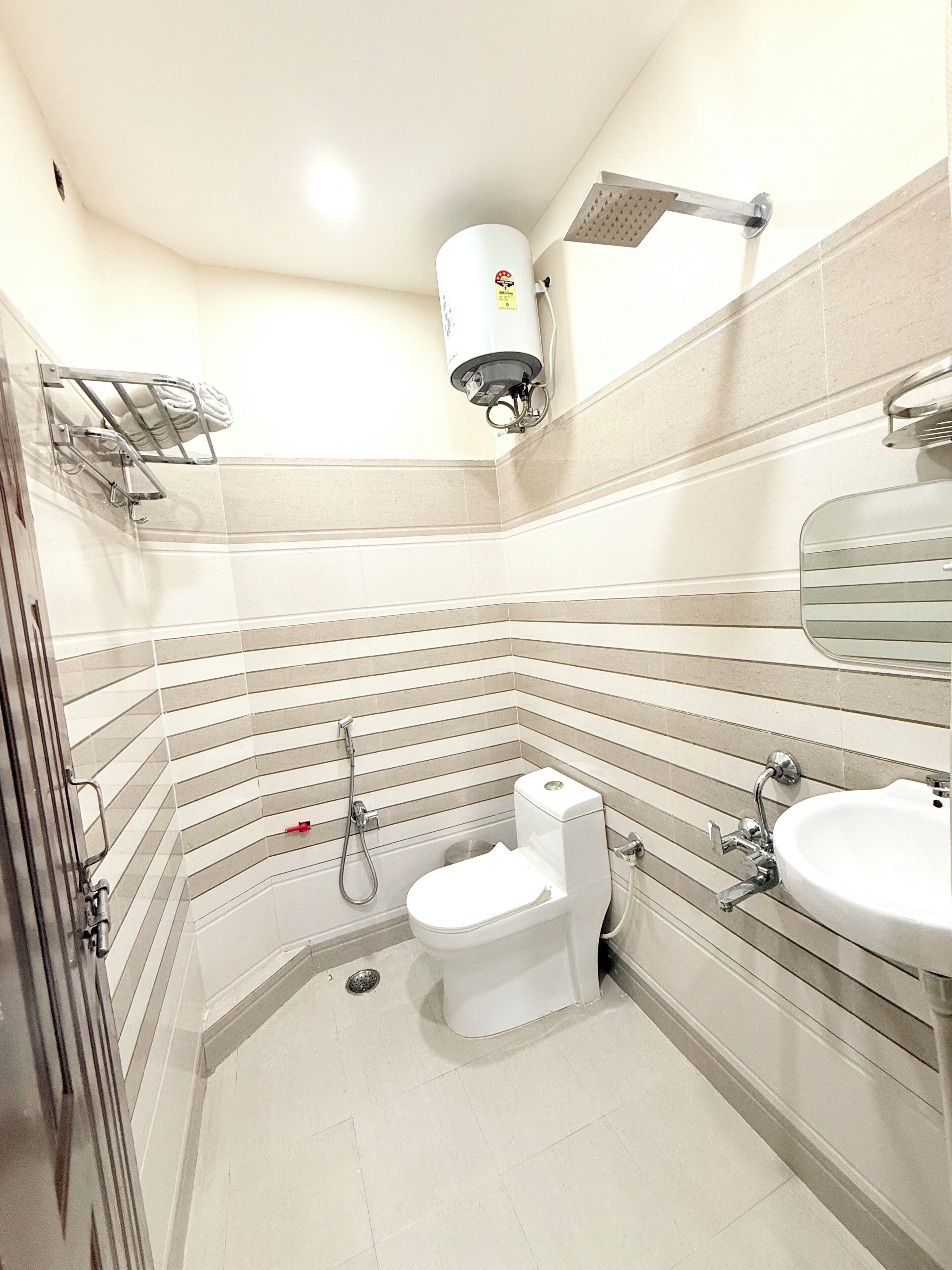 Une salle de bain équipée de toilettes, d’un lavabo, d’une douche et d’un porte-serviettes.