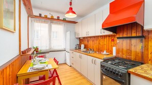 Una cocina compacta con armarios de madera, estufa y comedor con mesa y sillas.