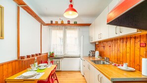 Una cocina compacta con armarios de madera, una estufa y un comedor con mesa y sillas.