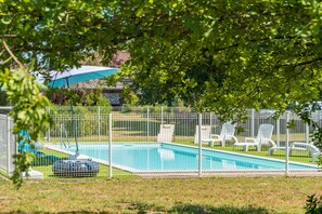 A swimming pool with a fence, lounge chairs, and a covered area. - "Lodge 1" with Shared Pool, Private Terrace and Shared Garden (Lesperon)
