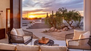 A modern outdoor seating area with a view of a sunset and desert landscape. - Sun-drenched escape w/ sleek saltwater pool (Todos Santos)