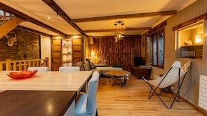 A cozy interior with a wooden dining table, a sofa, and a chair.