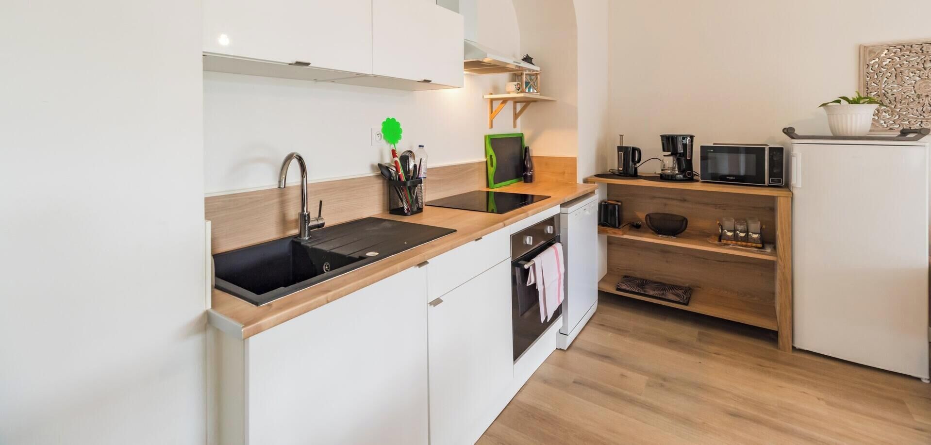 Une cuisine moderne équipée d’un évier, d’une cuisinière, d’un four à micro-ondes et d’une machine à café.