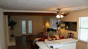 A dining area with a white table, red tableware, and a ceiling fan. - [Townhome] - El Fuerte (Riverdale)