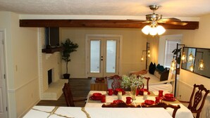 A dining area with a white table set for four, wooden chairs, a ceiling fan, and a fireplace. - [Townhome] - El Fuerte (Riverdale)