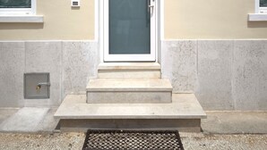 A beige building with a white-framed door, a small window, and a number '26' on the wall. - SG Family - Villa Secolo (Peschiera del Garda)