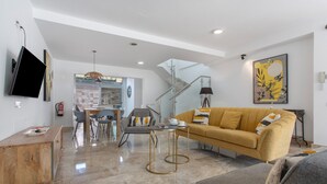 A modern living room with a sofa, coffee table, and TV.
