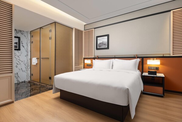 A hotel room with a large bed, a nightstand with a lamp, a picture on the wall, and a door with a view of the city. - Days Hotel By Wyndham Zhoushan Hi-Tech Zone (Zhoushan)