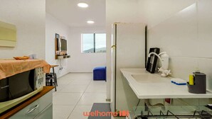 A compact kitchen with a microwave, a sink, and a window.