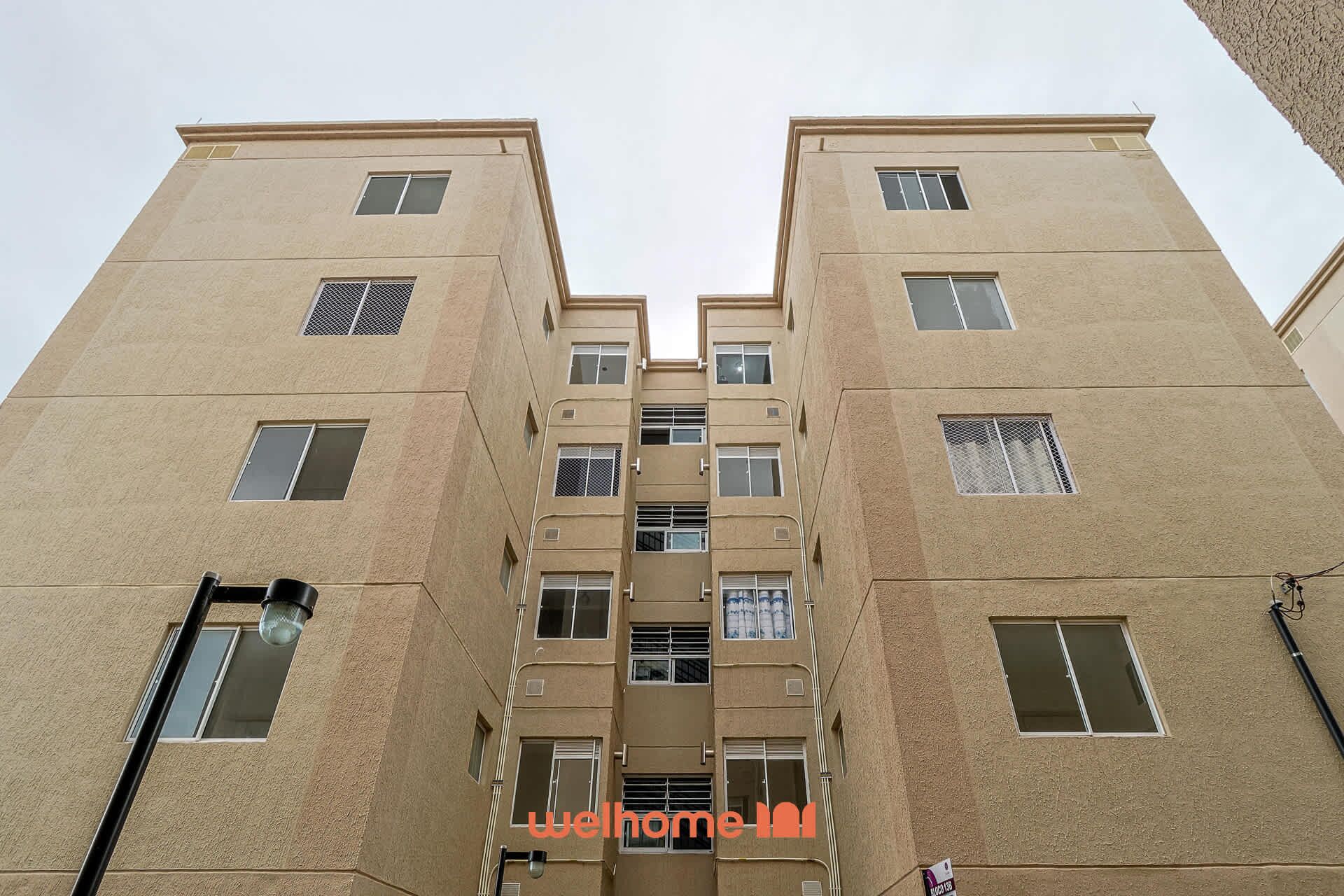 A multi-story building with a symmetrical facade, featuring evenly spaced windows and balconies.