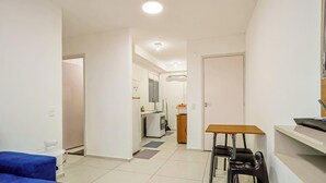 A modern apartment with a kitchen, dining area, and a small seating space.