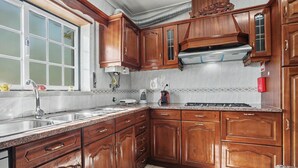 A kitchen with wooden cabinets, a stainless steel sink, and a window with frosted glass.