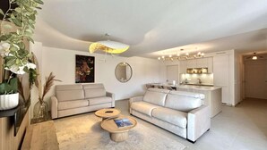 Ein modernes Wohnzimmer mit zwei Sofas, einem Couchtisch und einer Küche im Hintergrund.