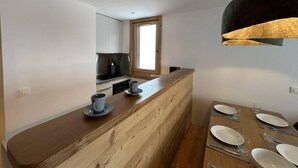 Una cucina moderna con isola in legno, forno a incasso e finestra sopra il lavello.