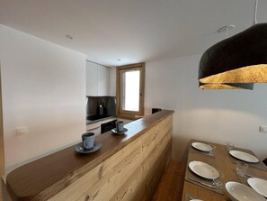 A modern kitchen with a wooden island, a built-in oven, and a window above the sink. - 35m from shops, 1st floor, terrace, 60m², Méribel-Mottaret (Méribel - Les Allues)