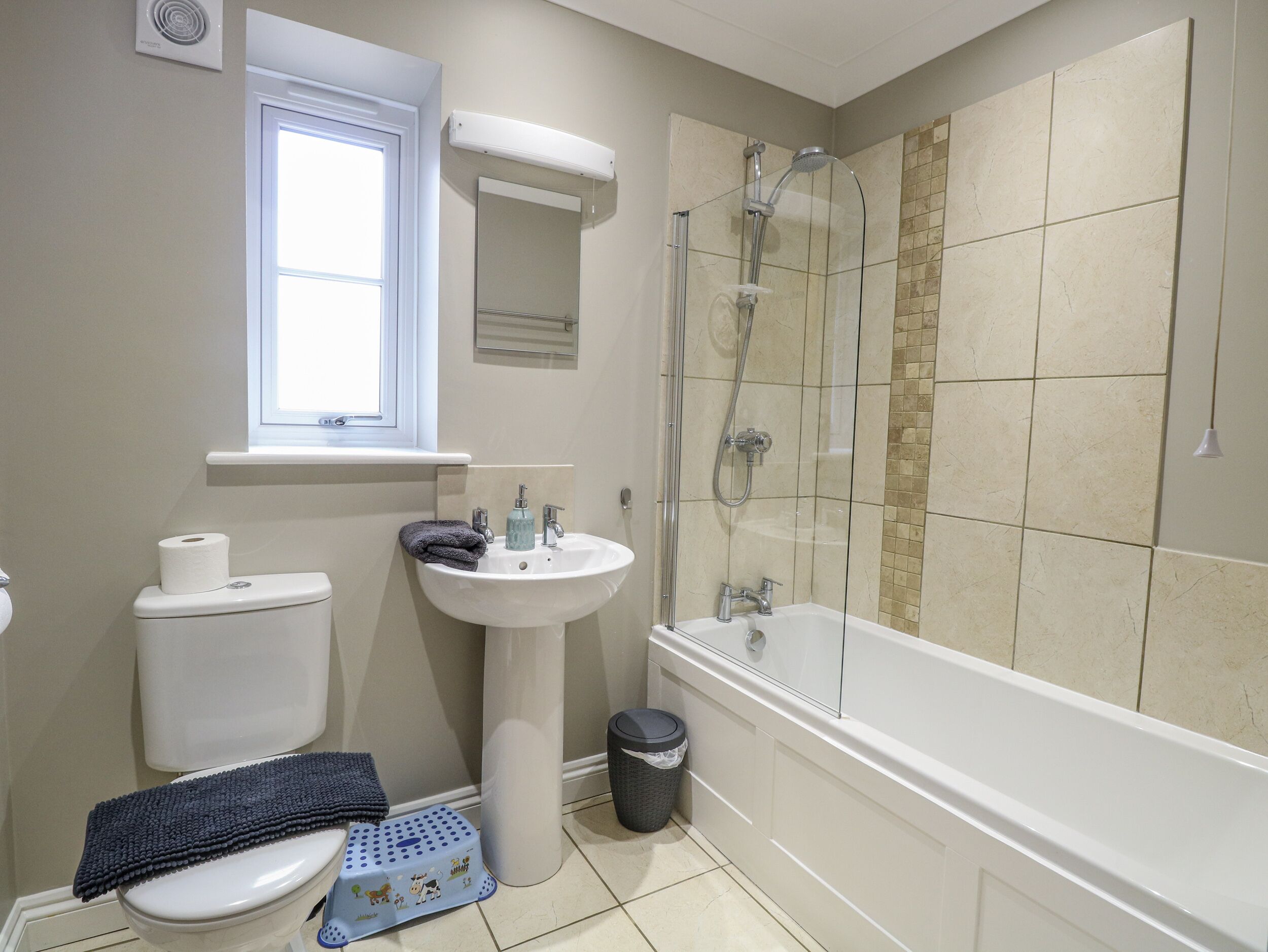A bathroom with a toilet, sink, and bathtub.