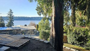 A deck with a view of a lake and forest. - Private & Serene 2BR with Amazing Lake Sammamish Views (Sammamish)