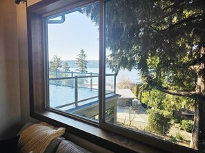 Una habitación con un ventanal grande que da a una terraza y una vista de árboles y un paisaje lejano.