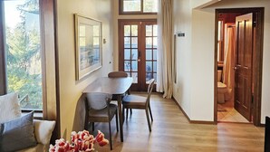 A dining area with a wooden table and chairs, a framed picture on the wall, and a view of the outdoors through a window. - Private & Serene 2BR with Amazing Lake Sammamish Views (Sammamish)