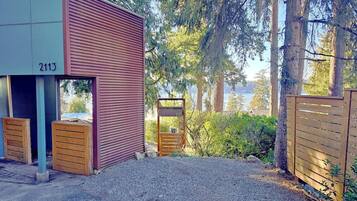 A building with a number 2113, a gravel driveway, and a wooden gate.