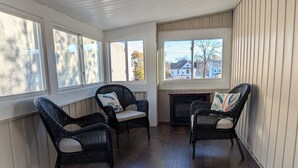 A spacious room with a high ceiling, large windows, and a fireplace.