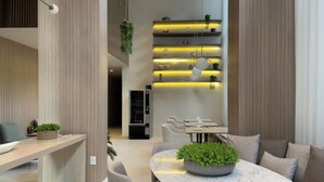 A modern interior with a reception desk, seating area, and a vending machine. - Lira Perdizes (Sao Paulo)