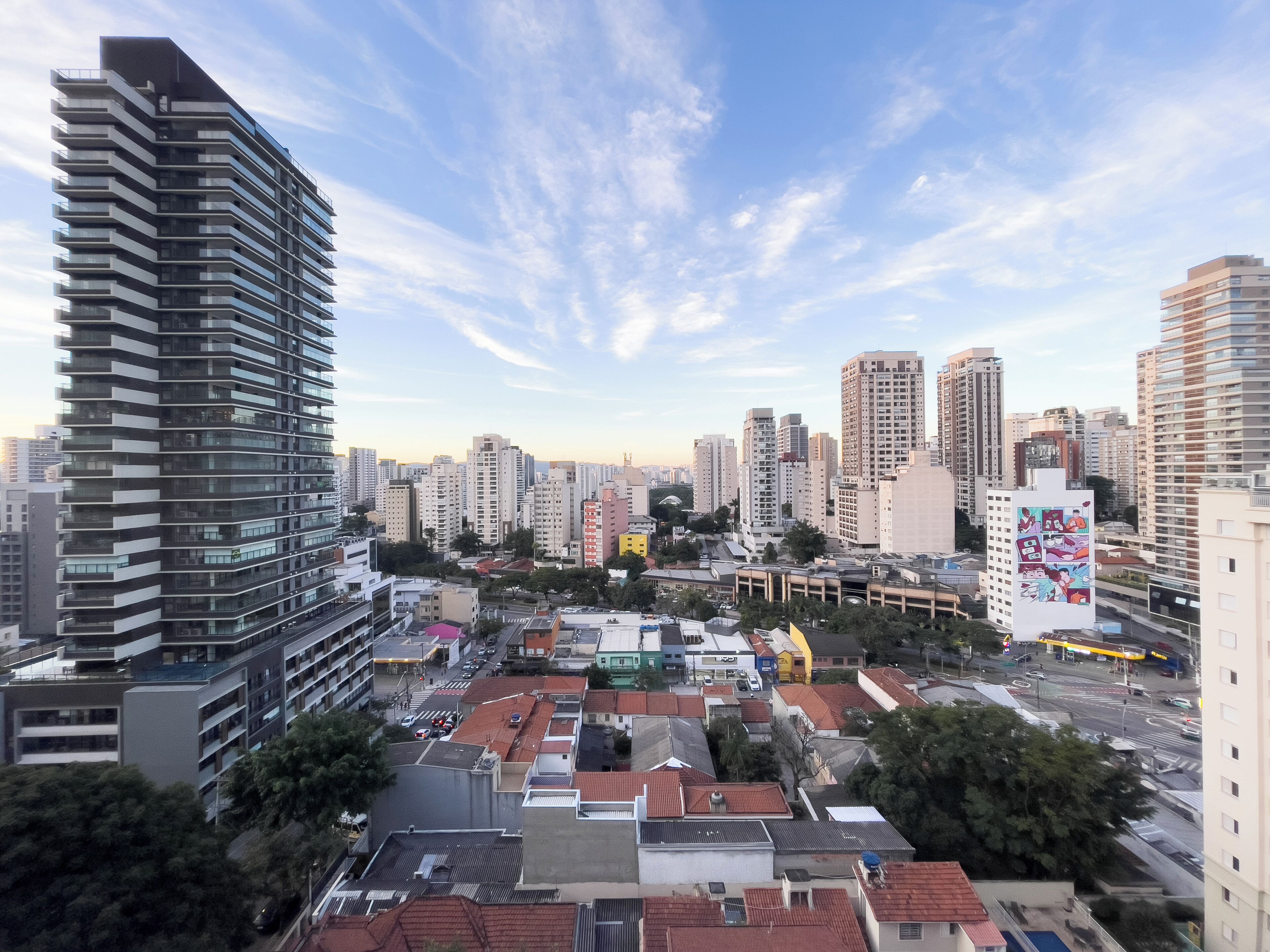 Un edificio de gran altura con un diseño arquitectónico moderno, rodeado de otros rascacielos en un paisaje urbano.