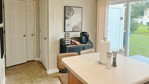 A kitchen with a countertop, a coffee maker, a salt and pepper set, and a picture on the wall.