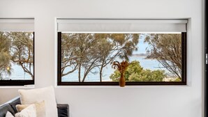 A room with a view of trees and water through a window. - Beachfront W/ Breathtaking Views (Blackmans Bay)