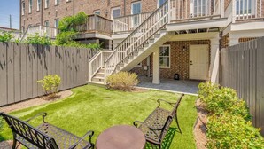 A brick building with a small backyard, a wooden fence, and a staircase leading to an upper level. - Rose House - 2 Primary Suites, Easy Parking (Savannah)