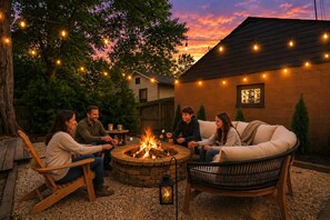 A group of people around a fire pit with string lights in a backyard setting. - Walk to OSU/Short North~FREE Parking~Modern Luxe (Columbus)