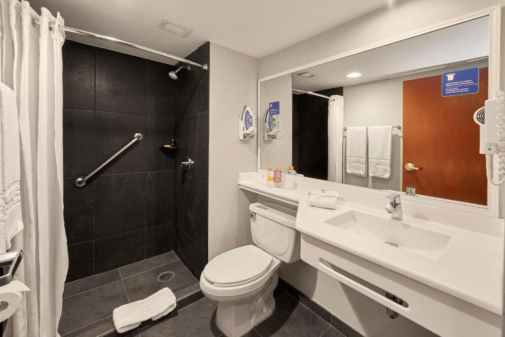 A modern bathroom with a shower, toilet, and sink.
