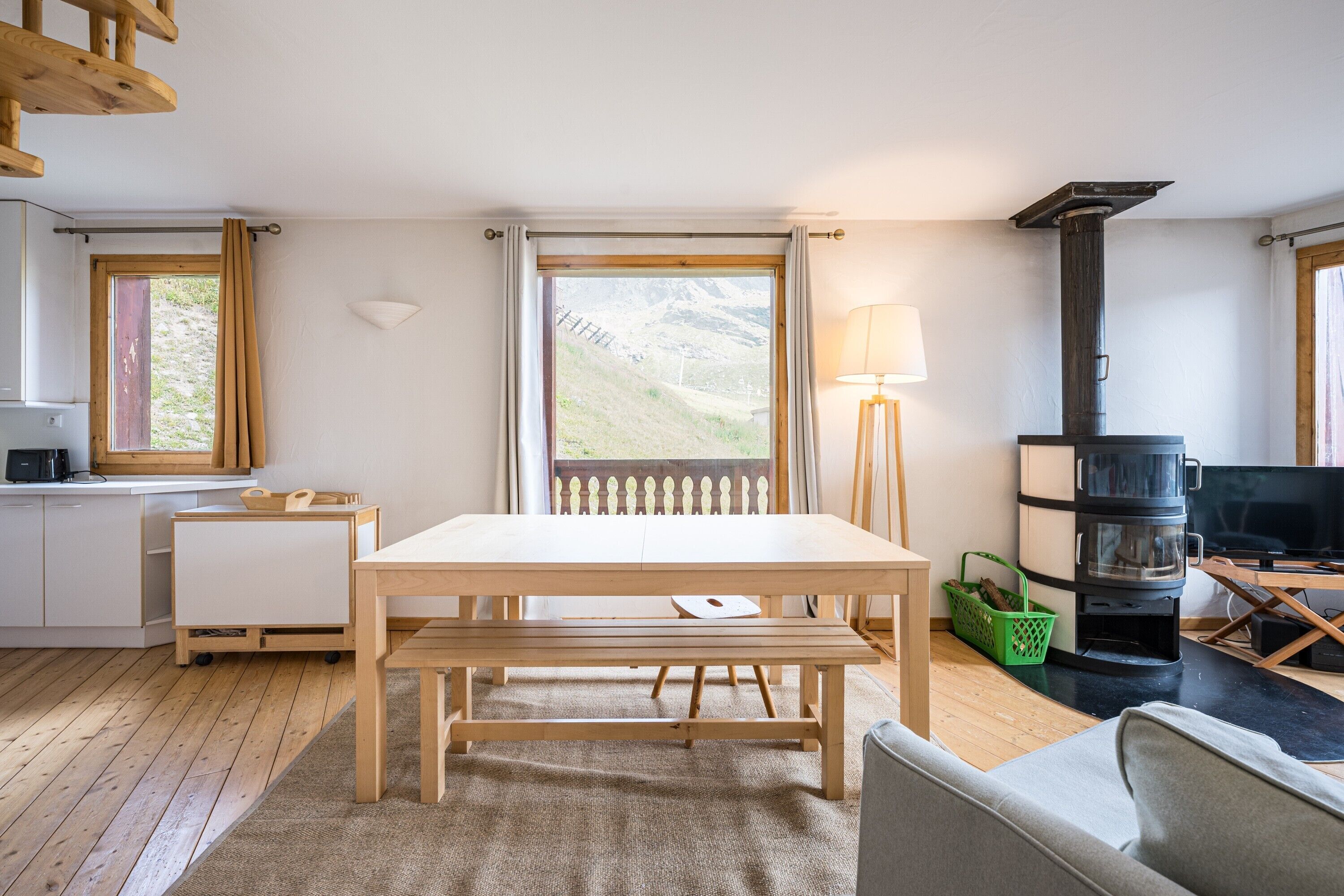 A modern interior with a wooden table, bench, and a sofa.