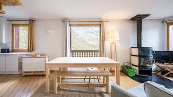 A modern interior with a wooden table, bench, and a sofa.