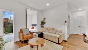 Ein modernes Wohnzimmer mit einer Couch, einem Couchtisch und einer Stehlampe.