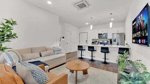Ein modernes Apartment mit Wohnzimmer, Küche und Essbereich.