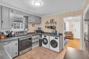 A compact kitchen with a stove, oven, microwave, and built-in washing machine.