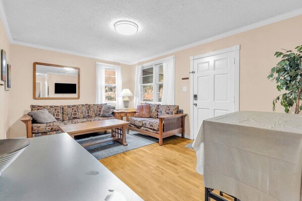 A cozy living room with a sofa, coffee table, and a television.